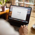 person using macbook pro on table