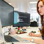 woman in green shirt sitting in front of computer