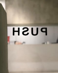 a bathroom with a push sign on the wall
