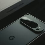 A close up of a cell phone near a laptop