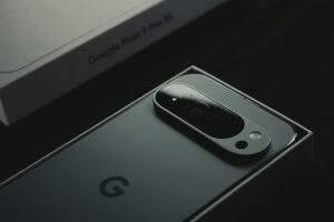 A close up of a cell phone near a laptop